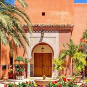 Modest hotel in Marrakech with traditional architecture and palm trees.